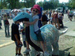 Mykala sitting on a painted dinosaur