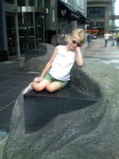 Mykala sitting on a rock sculpture on Nicollet Mall