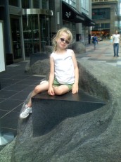 Mykala sitting on a rock sculpture on Nicollet Mall