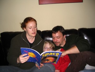 Mykala, Daddy and Corinne reading about space