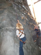 Mykala climbing a wall at REI