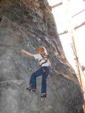 Mykala climbing a wall at REI