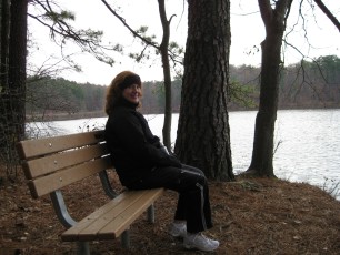 Corinne sitting on a bench by the lake