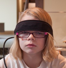 Mykala with a head band from a device that detects electrical brain activity signals