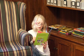Mykala reading in the library of the Bakken Museum.